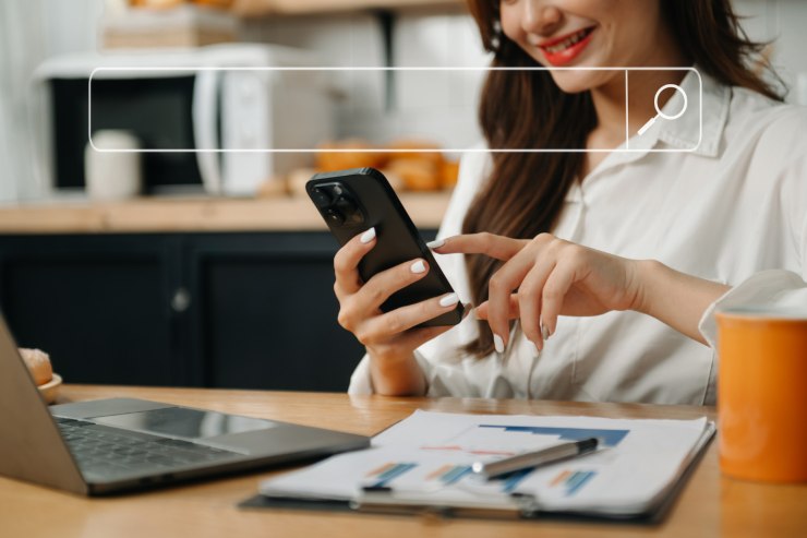 Ragazza sorridente mentre cerca lavoro con un'app di Intelligenza Artificiale sullo smartphone