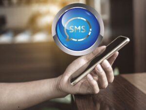 Mano che sorregge uno smartphone e logo sms
