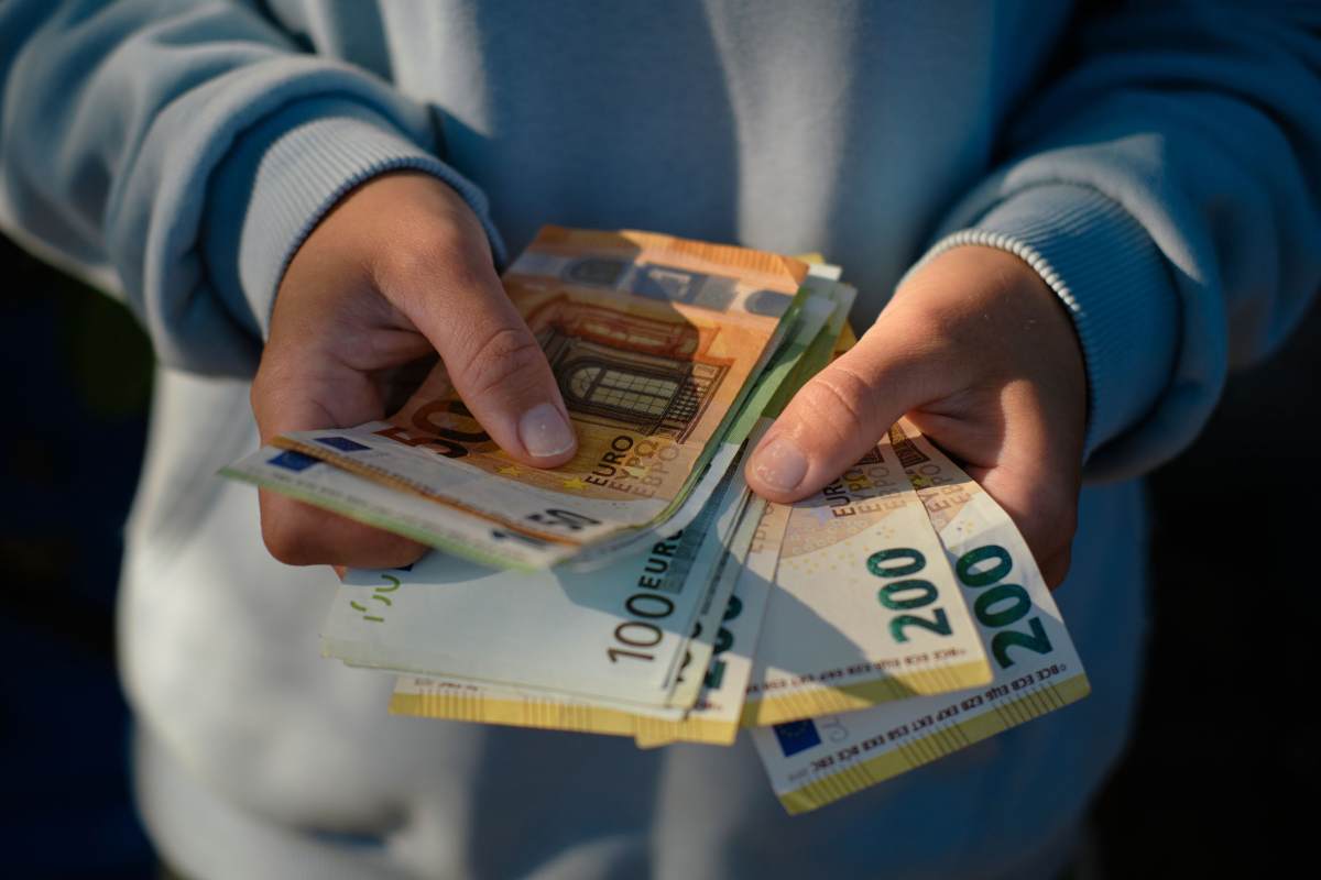 Persona tiene in mano delle banconote
