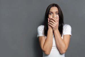 donna stupita e spaventata con le mani sulla bocca