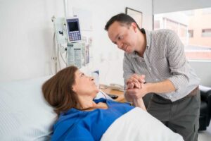 Uomo che tiene la mano di una donna in ospedale